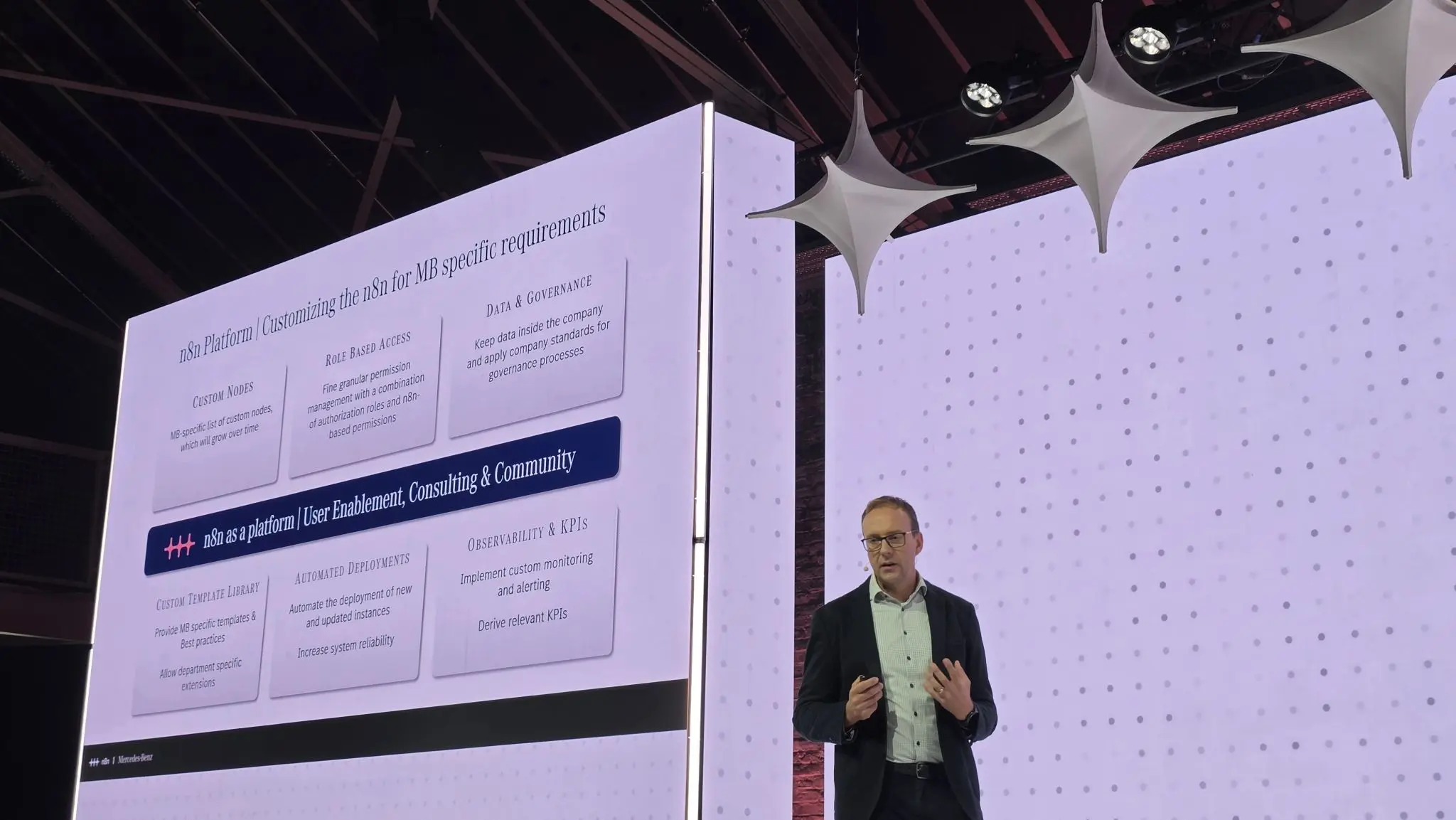 Slide titled n8n Platform, customizing n8n for Mercedes-Benz specific requirements, listing custom nodes, role based access, data and governance, custom templates, automated deployments, and observability and KPIs