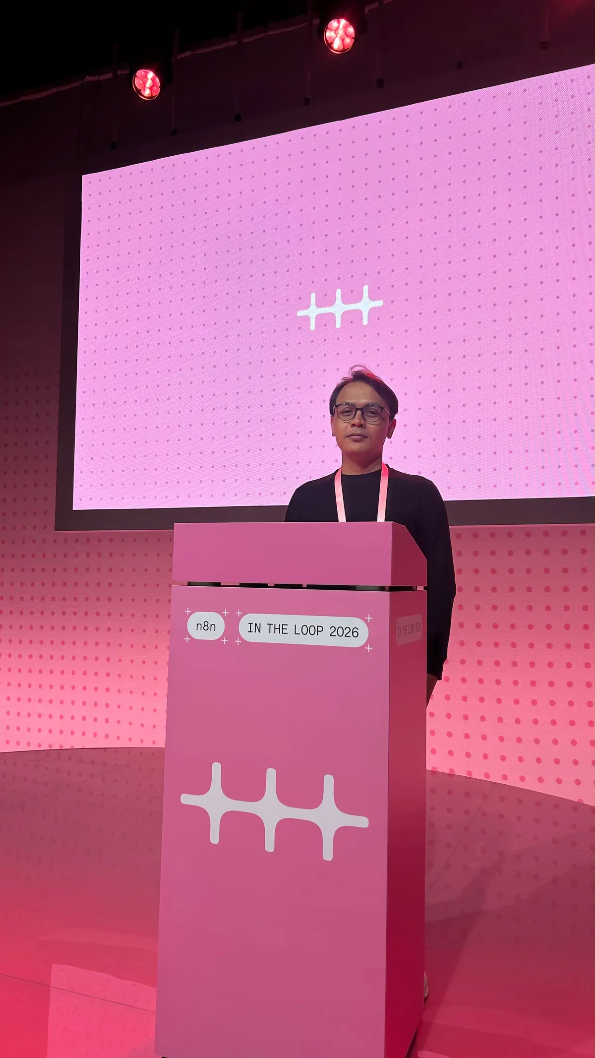 Khairul Muhtadin standing behind the n8n In The Loop 2026 podium on the main stage